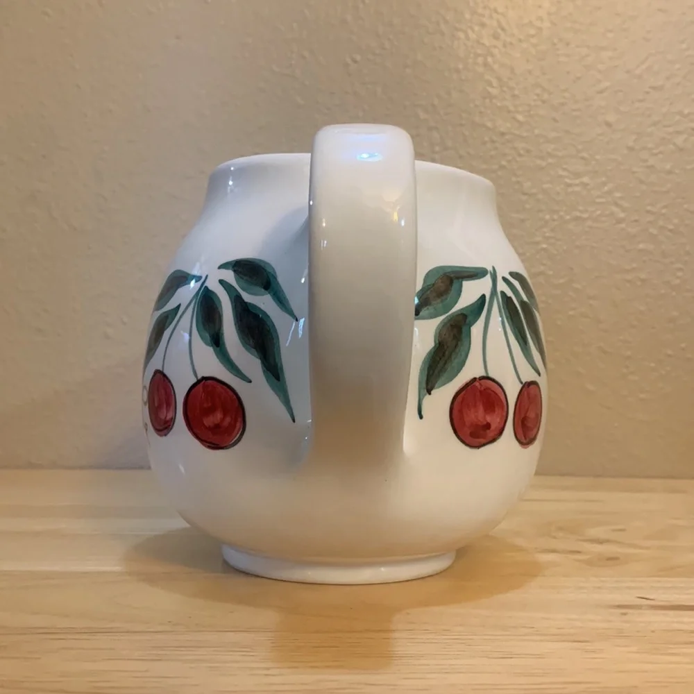 Crate & Barrel white ceramic pitcher hand painted with cherries and grapes.